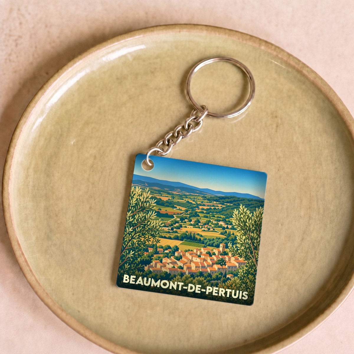Porte-clés souvenir de la ville de Beaumont-de-Pertuis avec une illustration stylisée d'un village provençal.