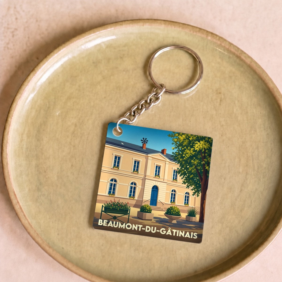 Porte-clés souvenir de la ville de Beaumont-du-Gâtinais avec une illustration stylisée de sa mairie.