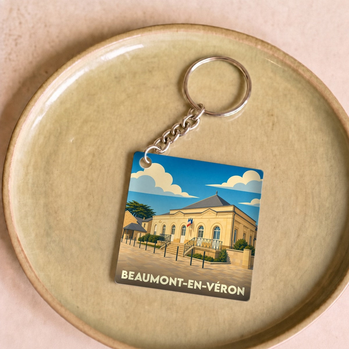 Porte-clés souvenir de la ville de Beaumont-en-Véron avec une illustration stylisée.