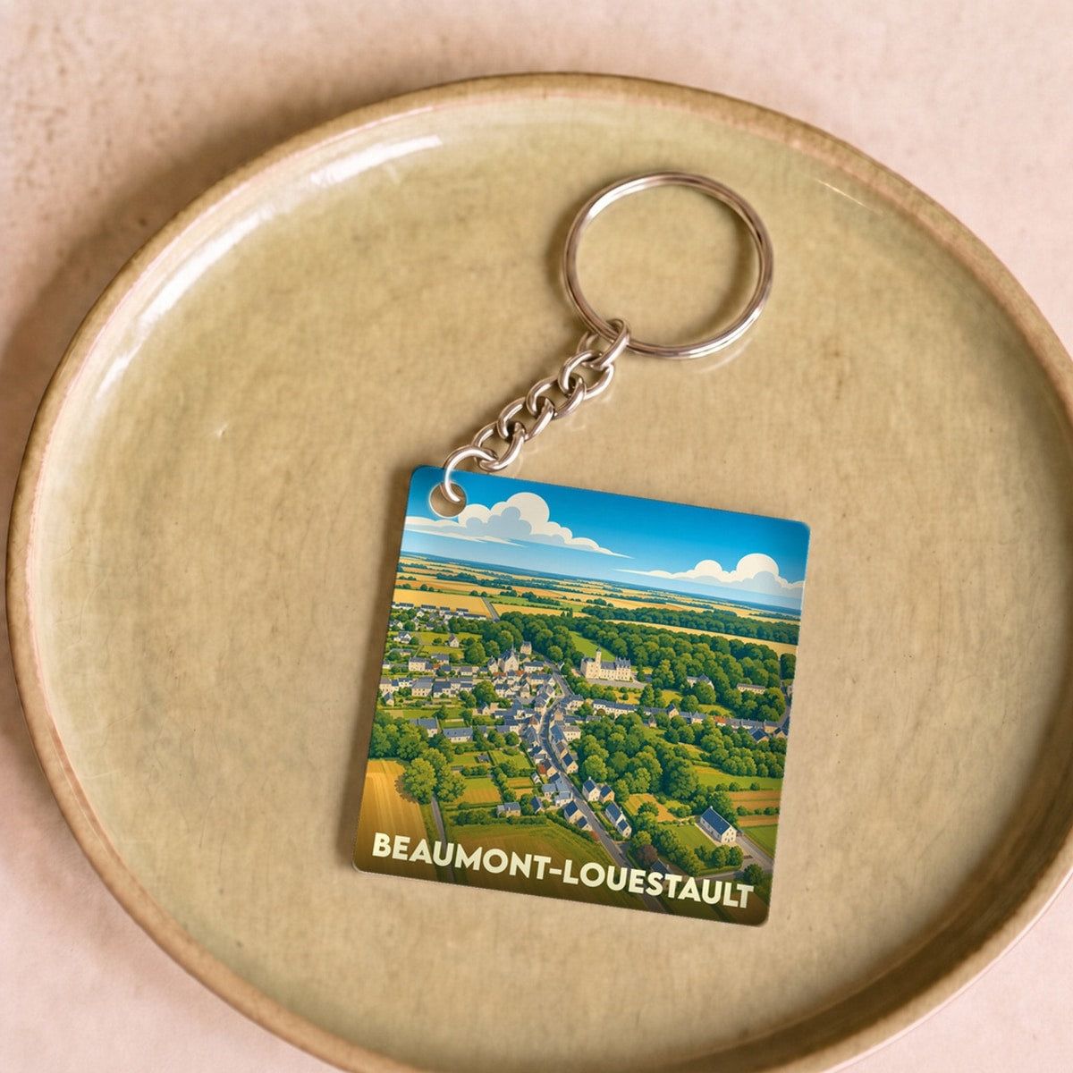 Porte-clés souvenir de la ville de Beaumont-Louestault avec une illustration stylisée.