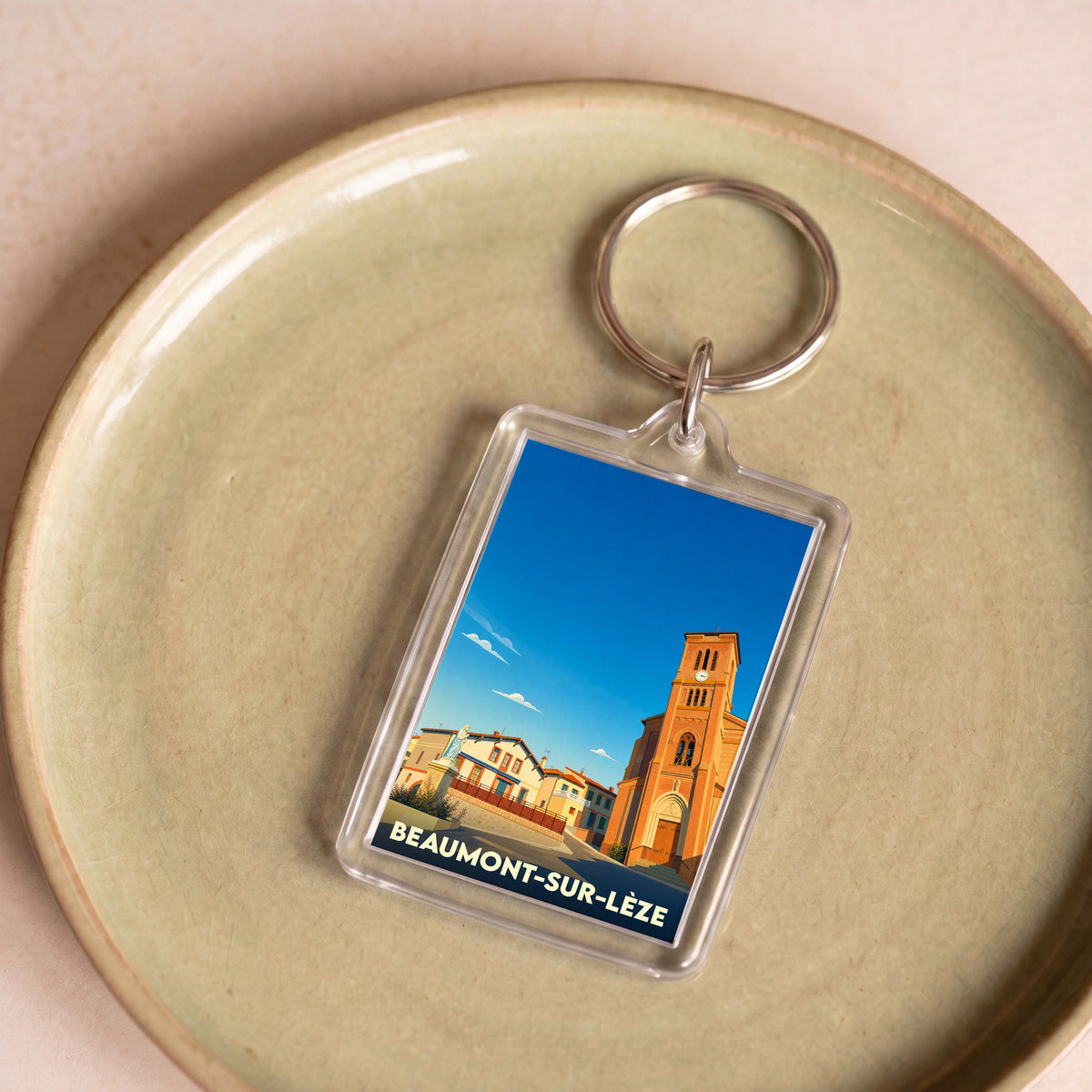 Porte-clés souvenir de la ville de Beaumont-sur-Lèze avec une illustration stylisée de son église.