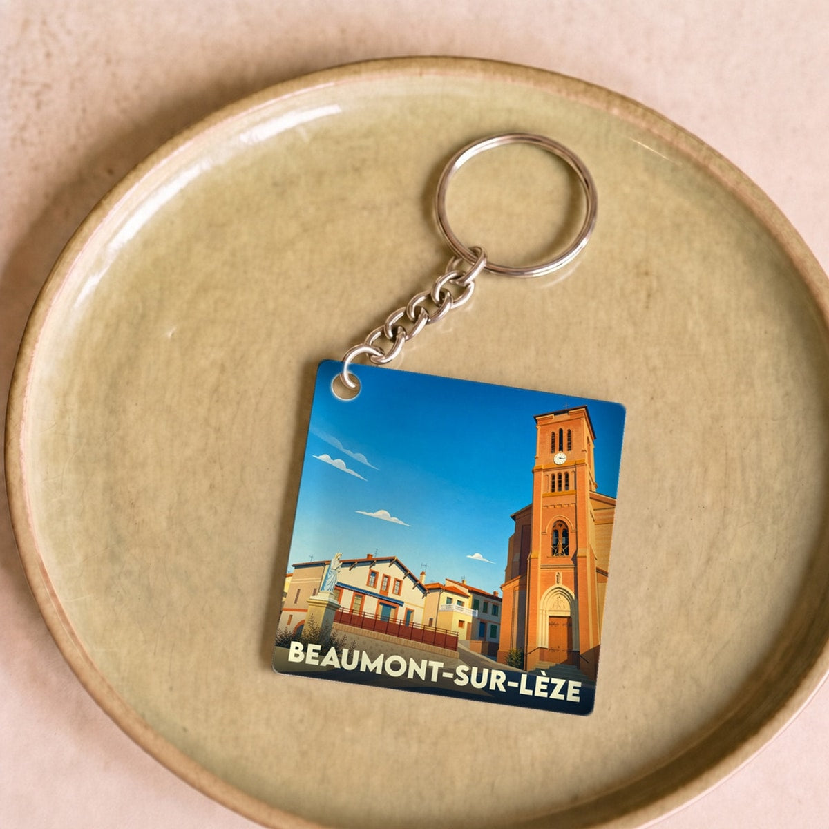 Porte-clés souvenir de la ville de Beaumont-sur-Lèze avec une illustration stylisée de son église.