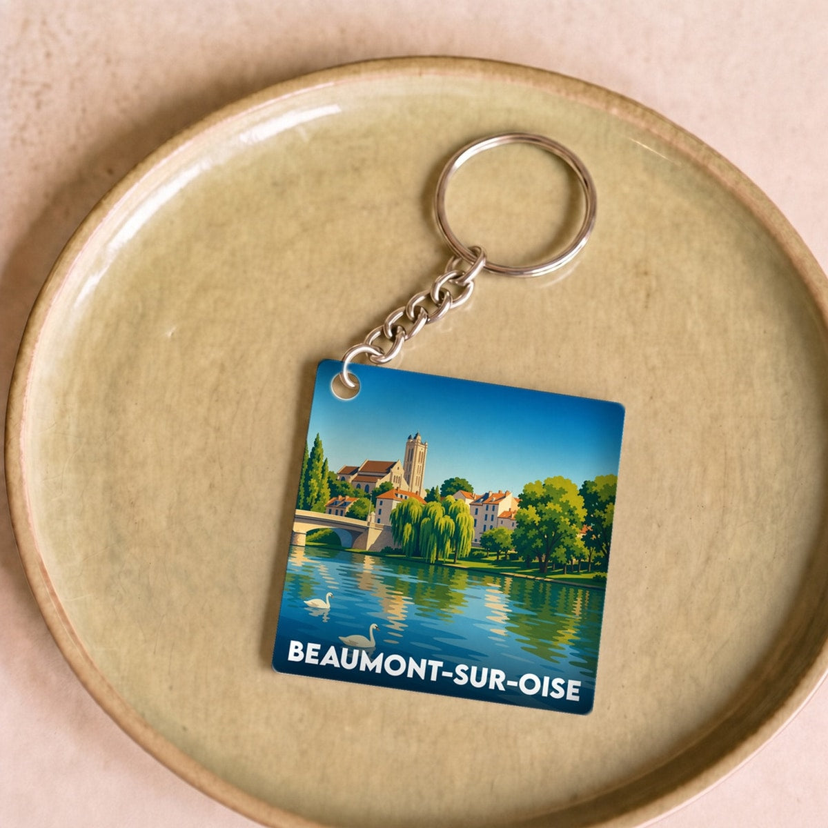 Porte-clés souvenir de Beaumont-sur-Oise avec une illustration stylisée des bords de l'Oise.