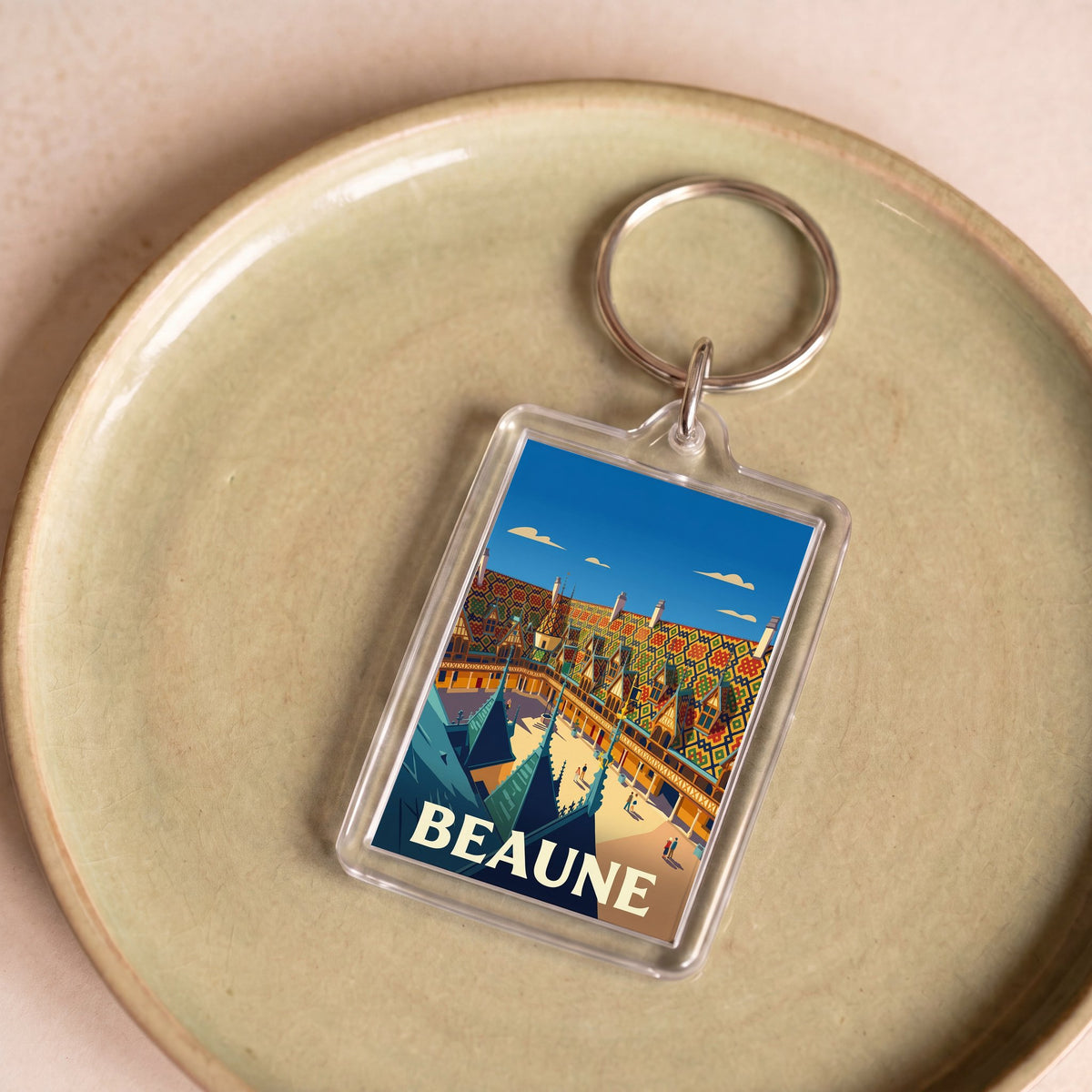 Porte-clés souvenir de la ville de Beaune avec une illustration stylisée.