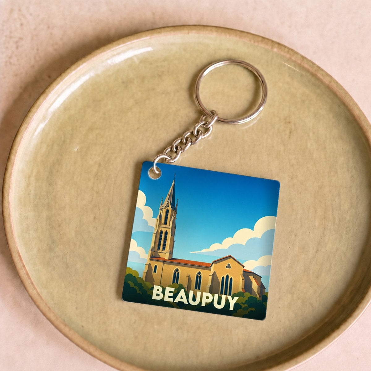 Porte-clés souvenir de la ville de Beaupuy avec une illustration stylisée de son église.