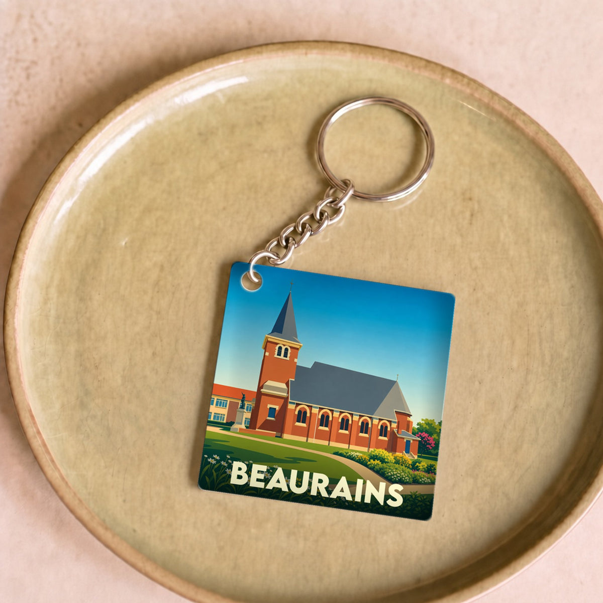 Porte-clés souvenir de la ville de Beaurains avec une illustration stylisée de son église.