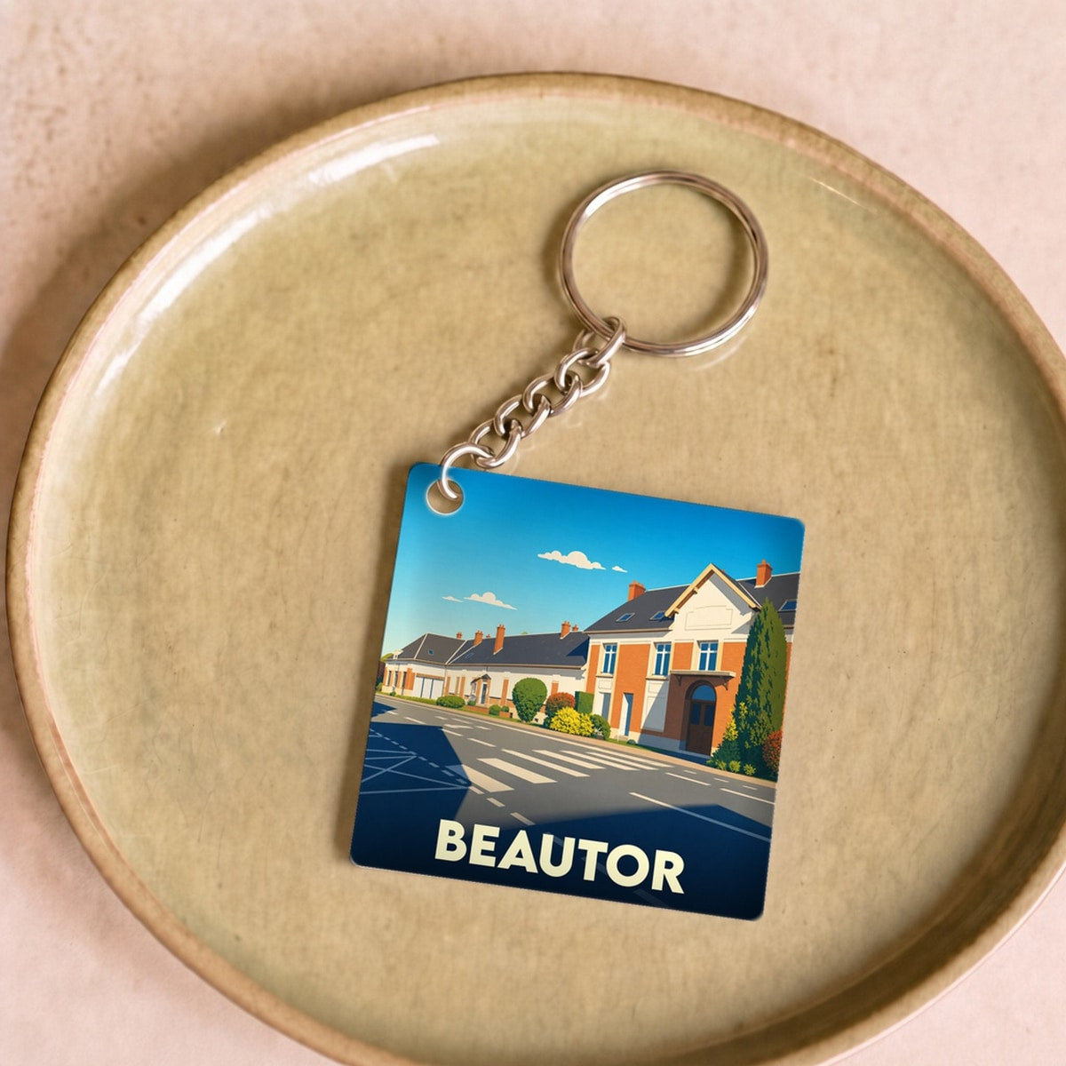 Porte-clés souvenir de la ville de Beautor avec une illustration stylisée.