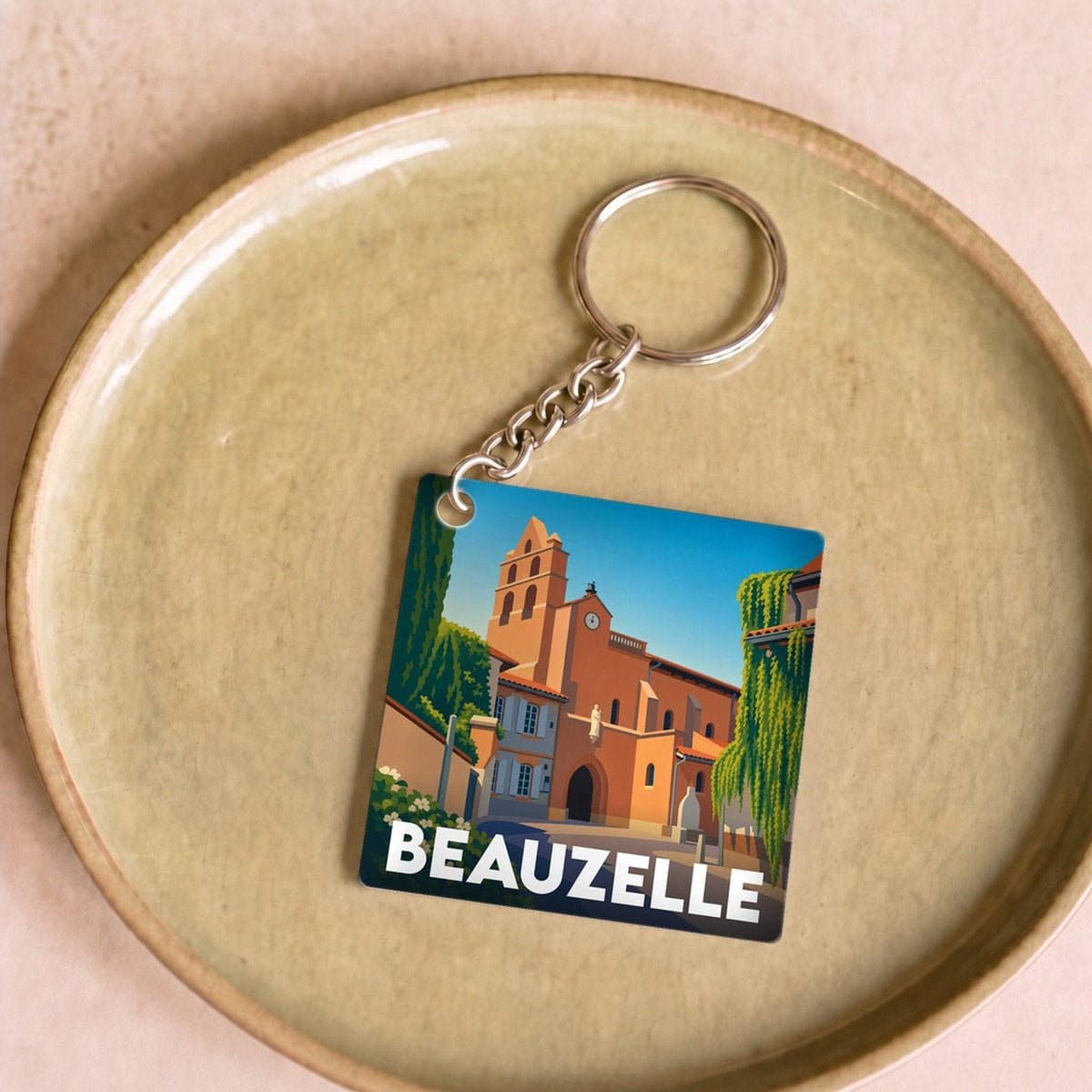 Porte-clés souvenir de la ville de Beauzelle avec une illustration stylisée.