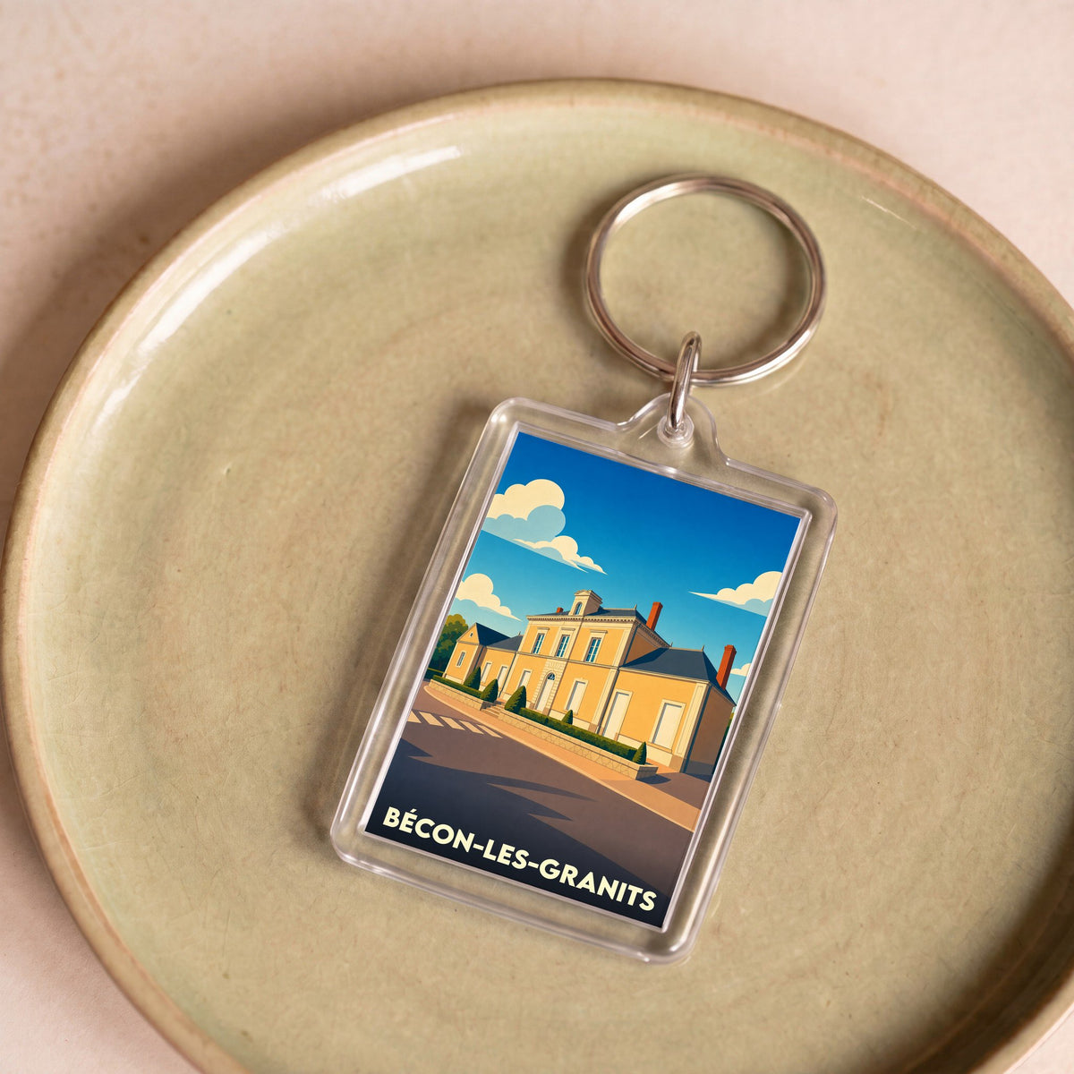 Porte-clés souvenir de la ville de Bécon-les-Granits avec une illustration stylisée de sa mairie.