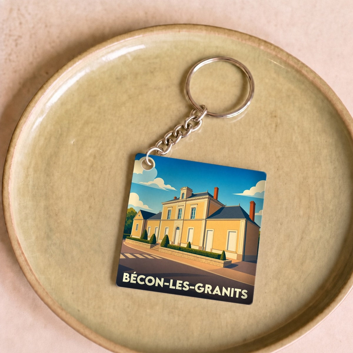 Porte-clés souvenir de la ville de Bécon-les-Granits avec une illustration stylisée de sa mairie.