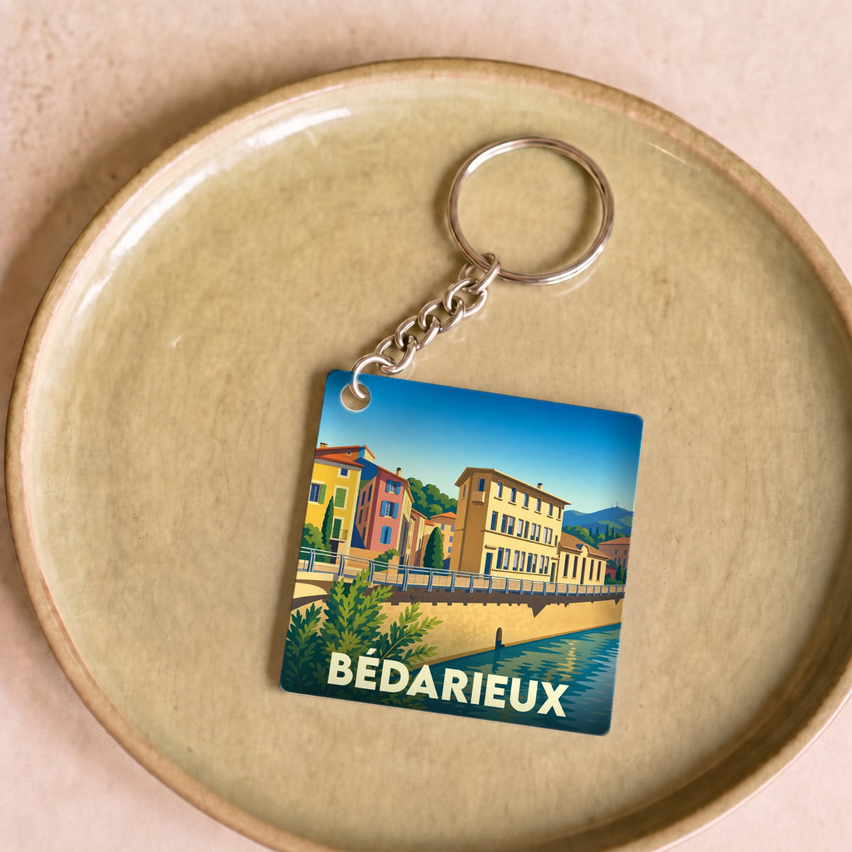 Porte-clés souvenir de la ville de Bédarieux avec une illustration stylisée.