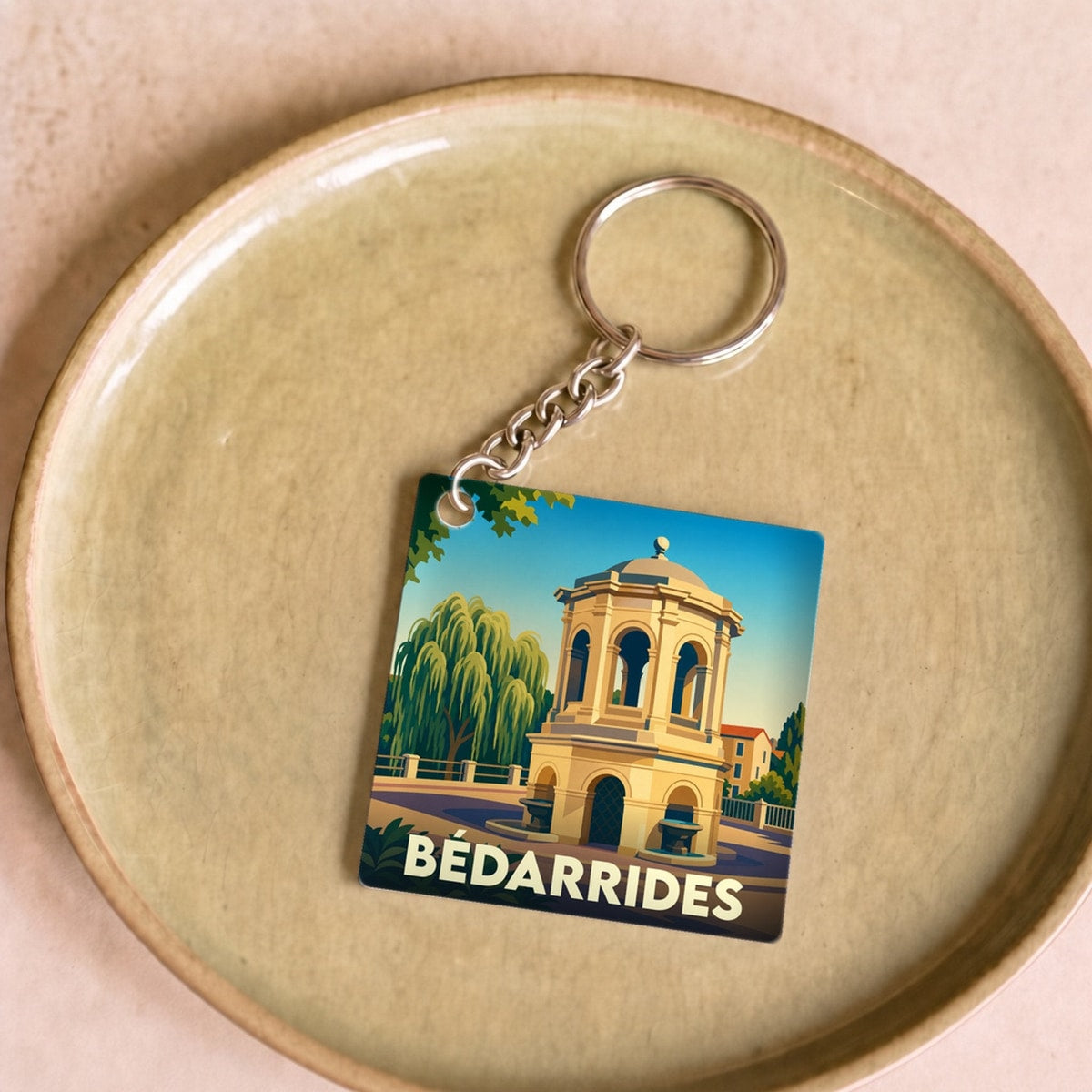 Porte-clés souvenir de la ville de Bédarrides avec une illustration stylisée d'un monument historique.