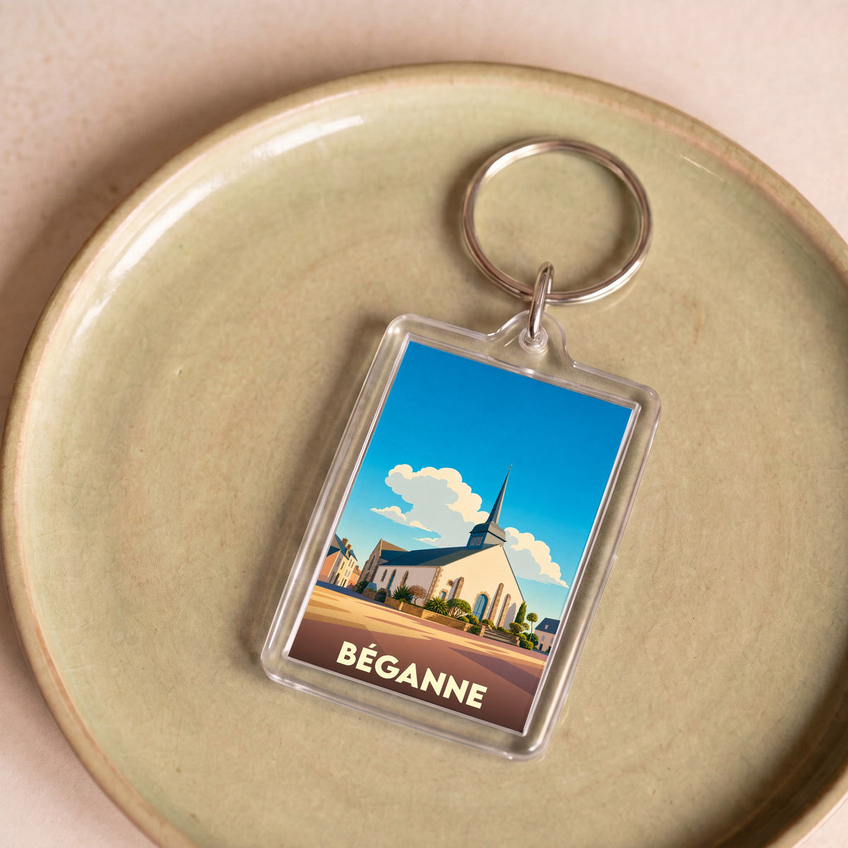 Porte-clés souvenir de la ville de Béganne avec une illustration stylisée de son église.