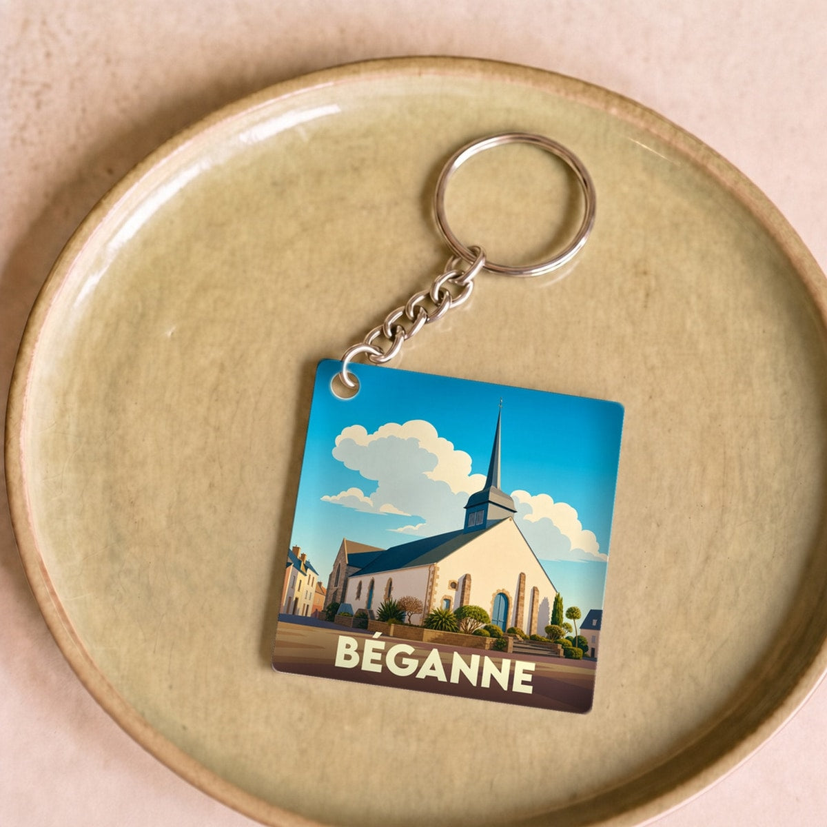 Porte-clés souvenir de la ville de Béganne avec une illustration stylisée de son église.