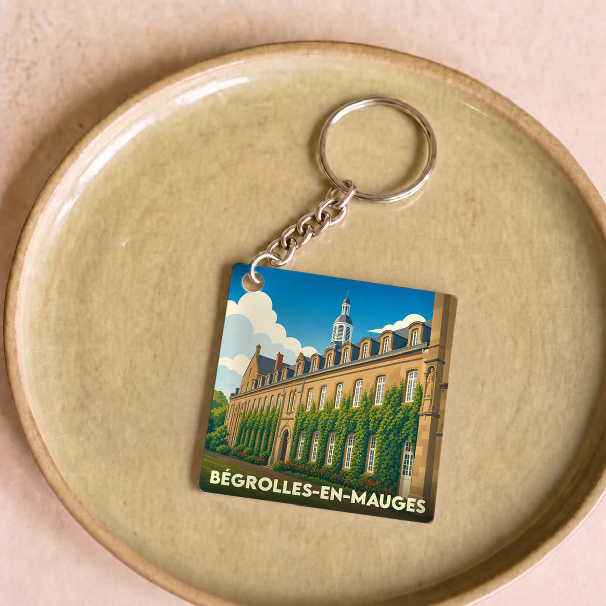 Porte-clés souvenir de la ville de Bégrolles-en-Mauges avec une illustration stylisée.