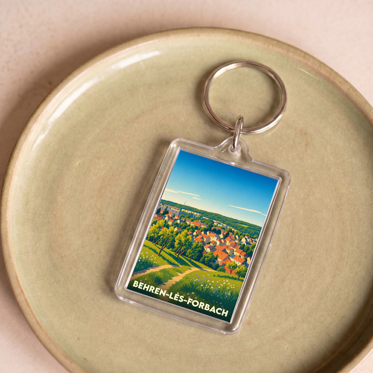 Porte-clés souvenir de la ville de Behren-lès-Forbach avec une illustration stylisée.