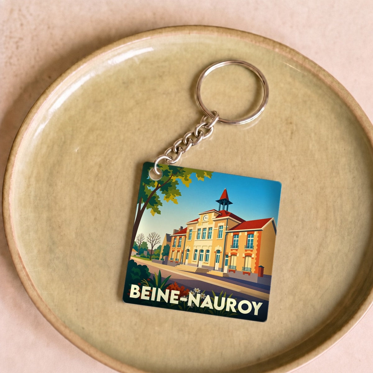 Porte-clés souvenir de la ville de Beine-Nauroy avec une illustration stylisée.