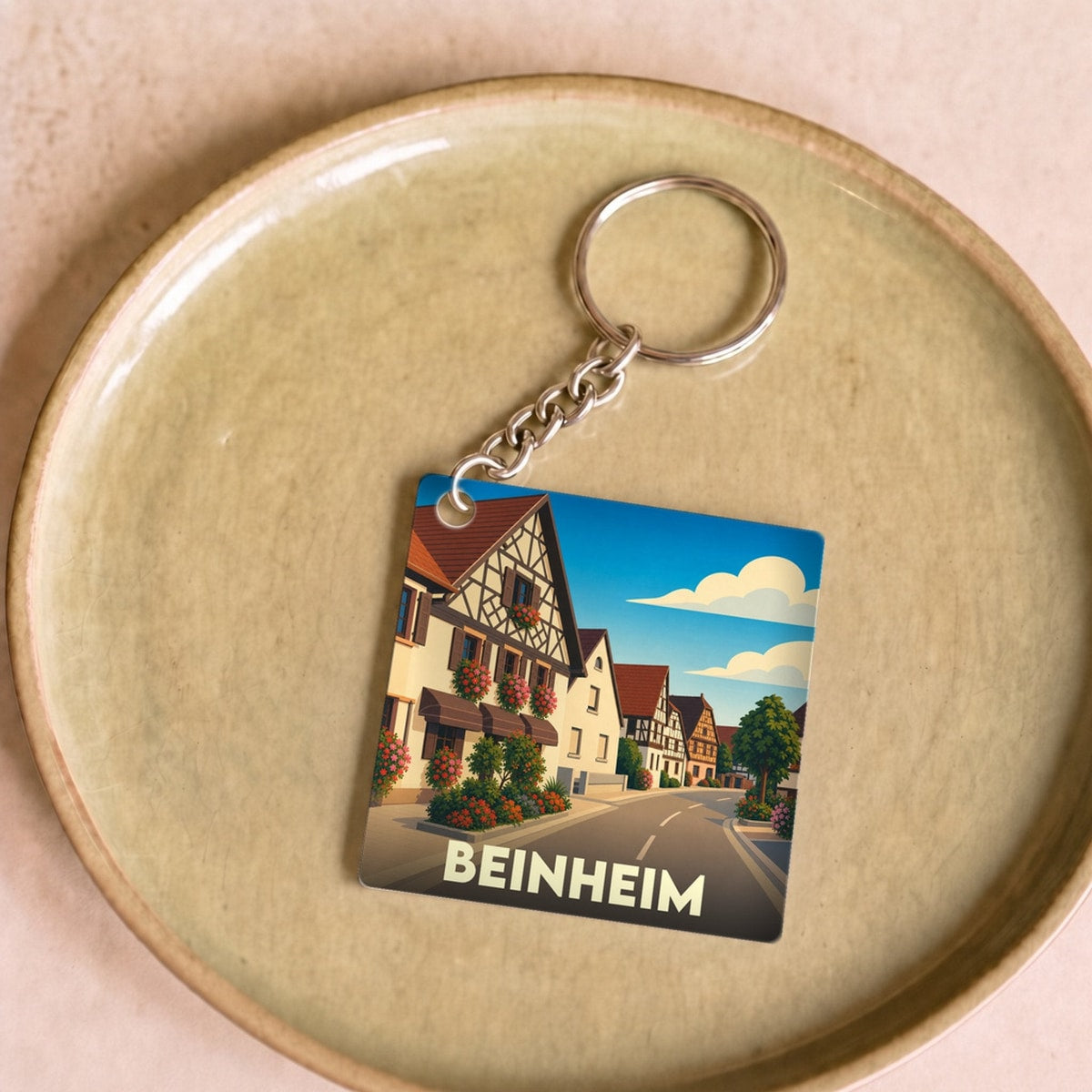 Porte-clés souvenir de la ville de Beinheim avec une illustration stylisée de ses maisons à colombages.