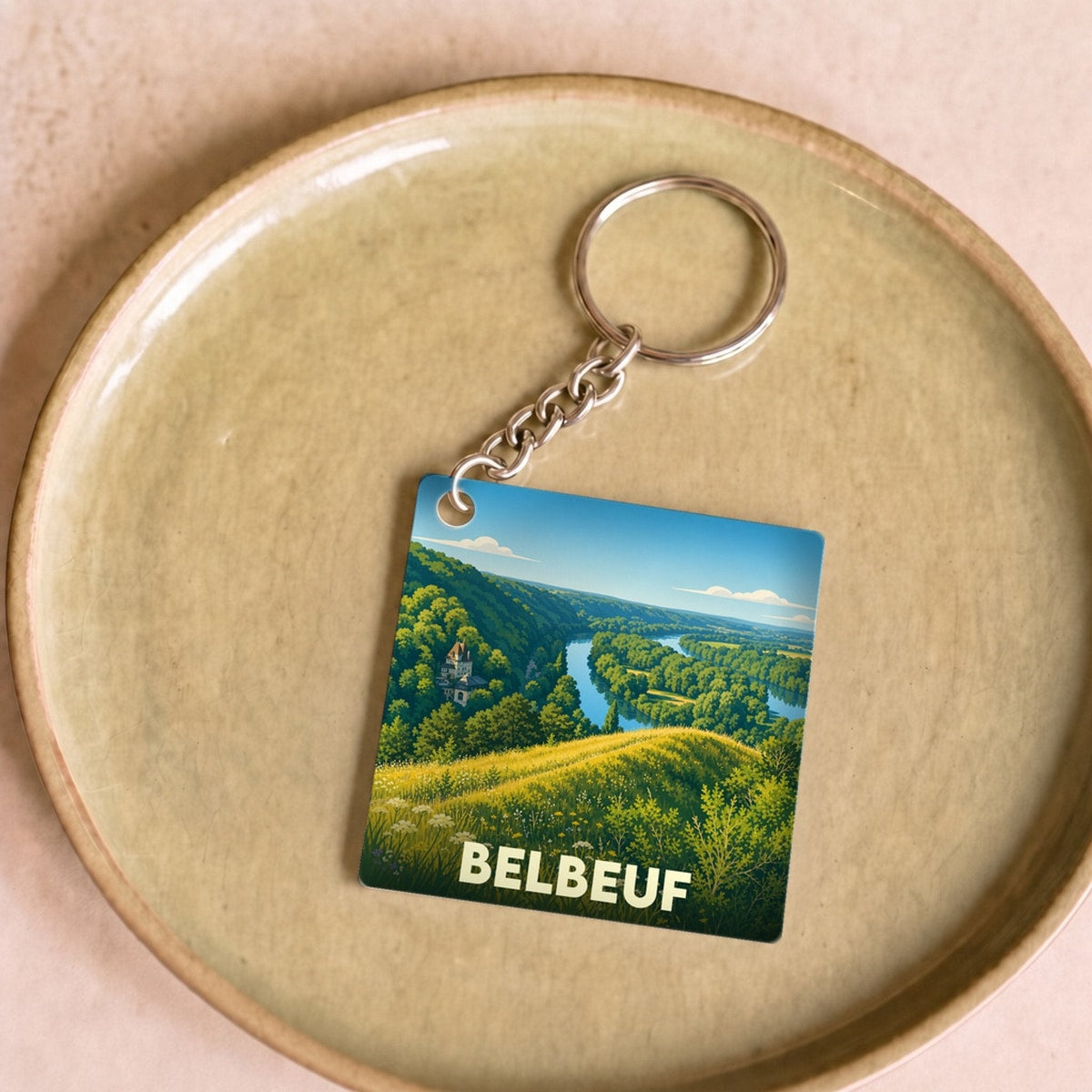Porte-clés souvenir de la ville de Belbeuf avec une illustration stylisée d'un paysage naturel.