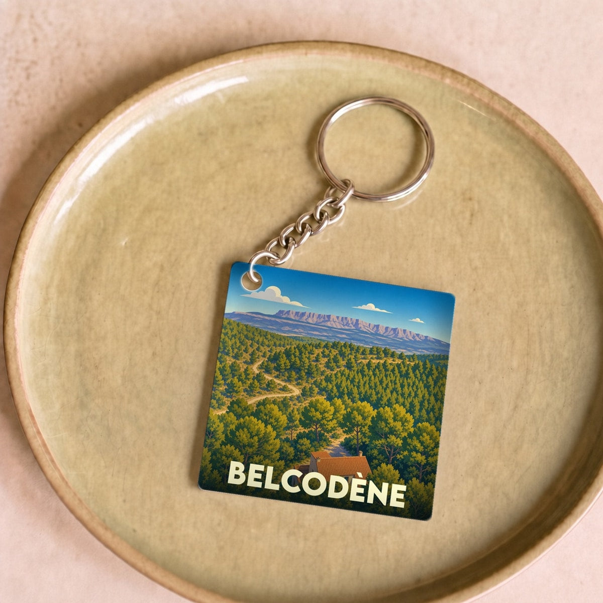 Porte-clés souvenir de la ville de Belcodène avec une illustration stylisée d'un paysage provençal.