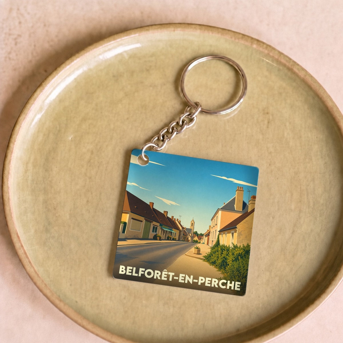 Porte-clés souvenir de Belforêt-en-Perche avec une illustration stylisée de la ville.