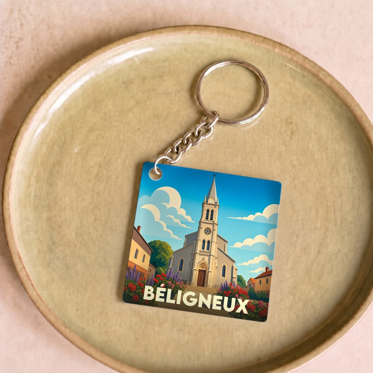 Porte-clés souvenir de la ville de Béligneux avec une illustration stylisée de son église.