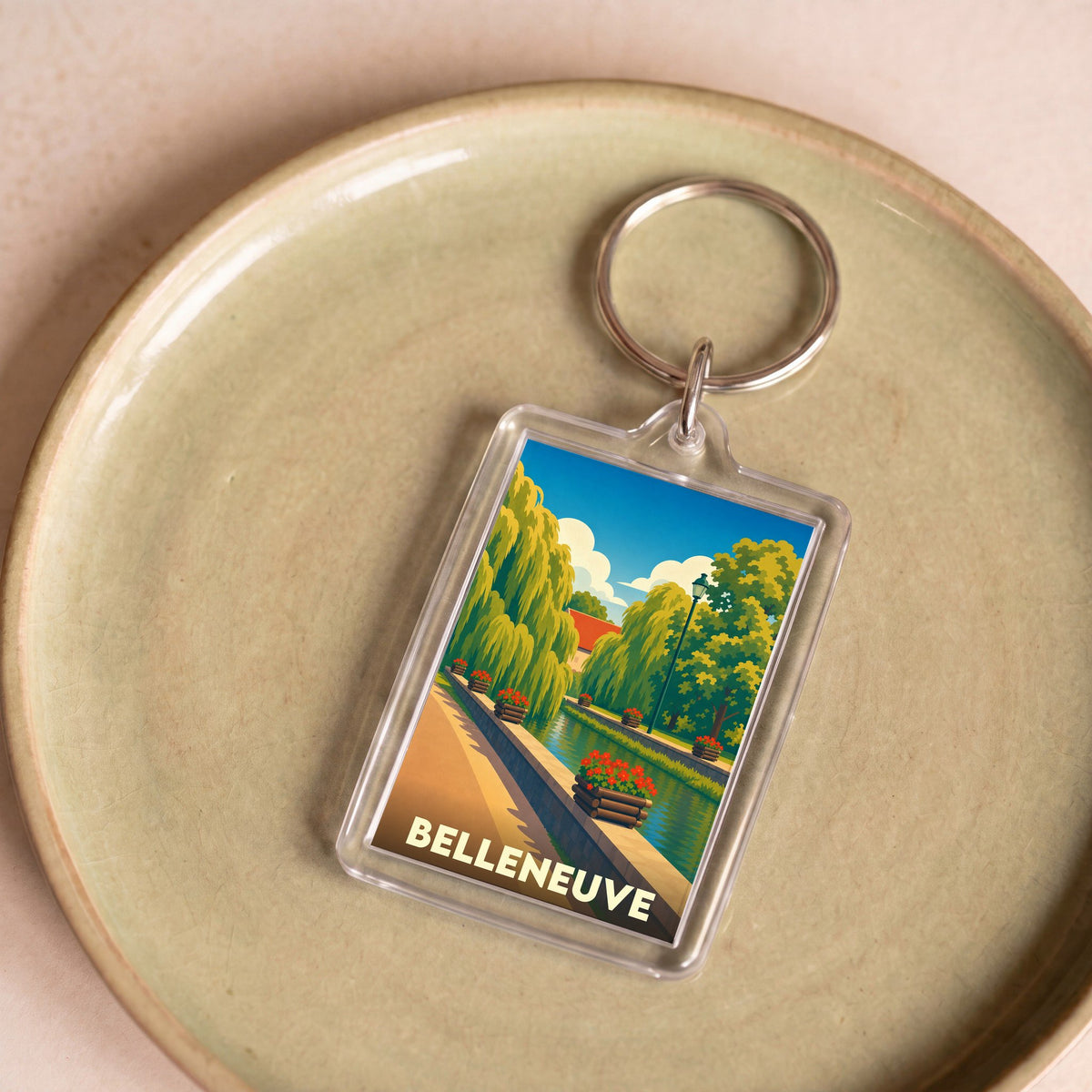 Porte-clés souvenir de la ville de Belleneuve avec une illustration stylisée d'un canal fleuri.