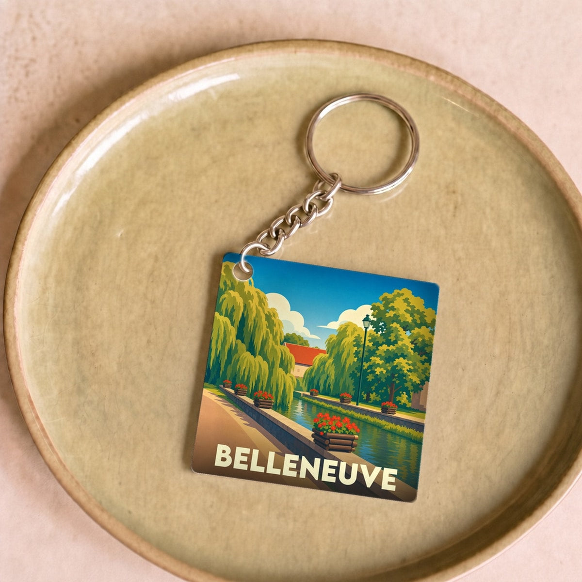 Porte-clés souvenir de la ville de Belleneuve avec une illustration stylisée d'un canal fleuri.