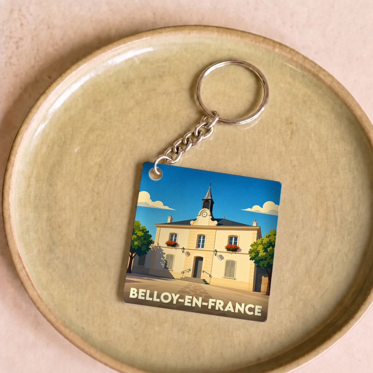 Porte-clés souvenir de la ville de Belloy-en-France avec une illustration stylisée de sa mairie.
