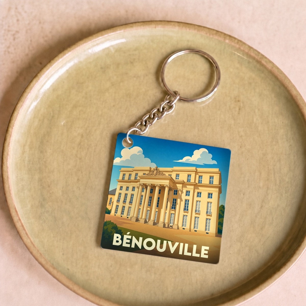 Porte-clés souvenir de la ville de Bénouville avec une illustration stylisée de son château.