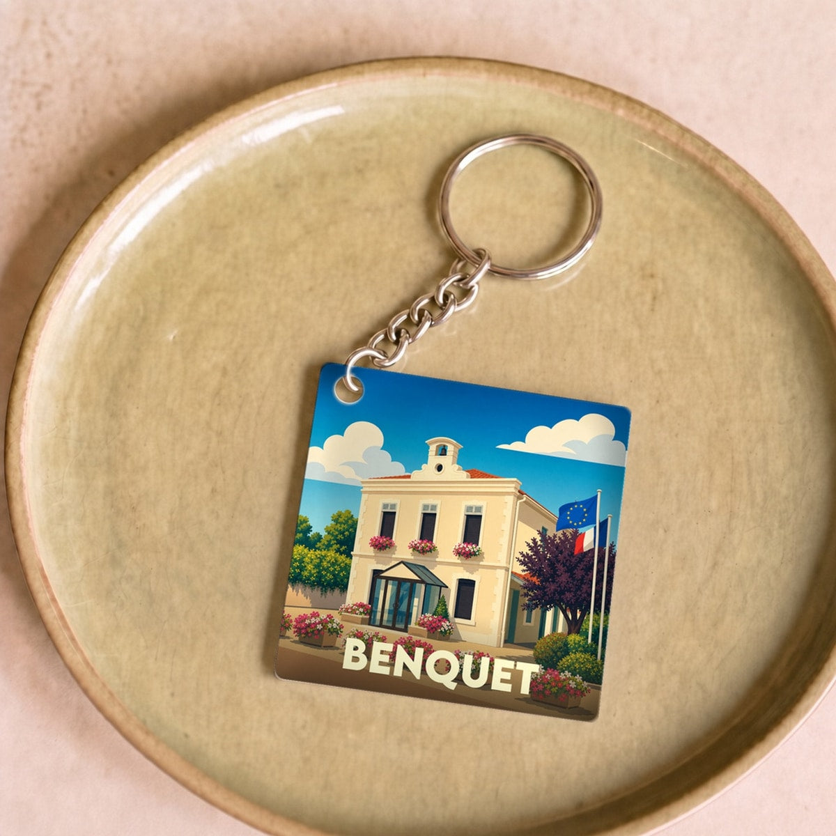 Porte-clés souvenir de la ville de Benquet avec une illustration stylisée.