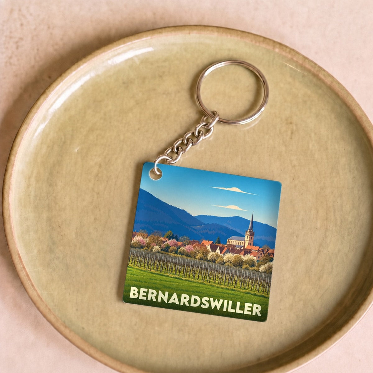 Porte-clés souvenir de la ville de Bernardswiller avec une illustration stylisée d'un paysage alsacien.