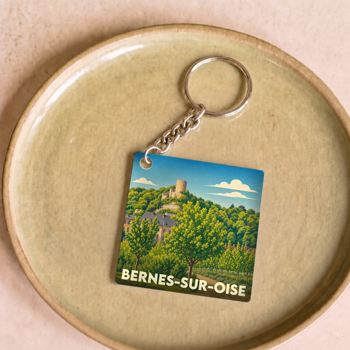 Porte-clés souvenir de la ville de Bernes-sur-Oise avec une illustration stylisée.