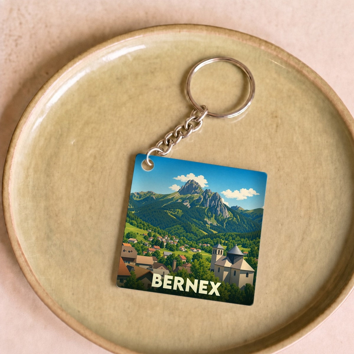 Porte-clés souvenir de la ville de Bernex avec une illustration stylisée de ses montagnes et son village.