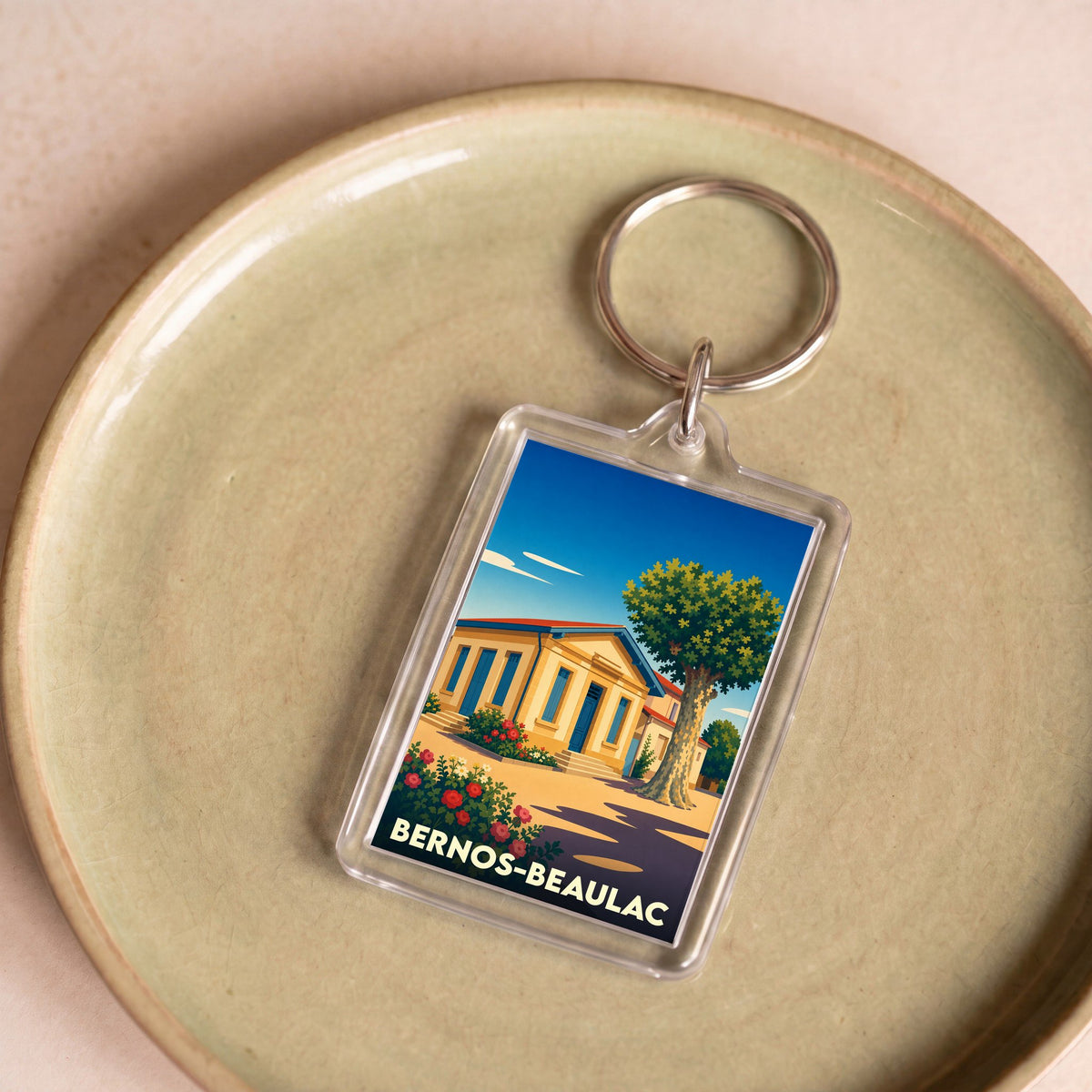 Porte-clés souvenir de la ville de Bernos-Beaulac avec une illustration stylisée.