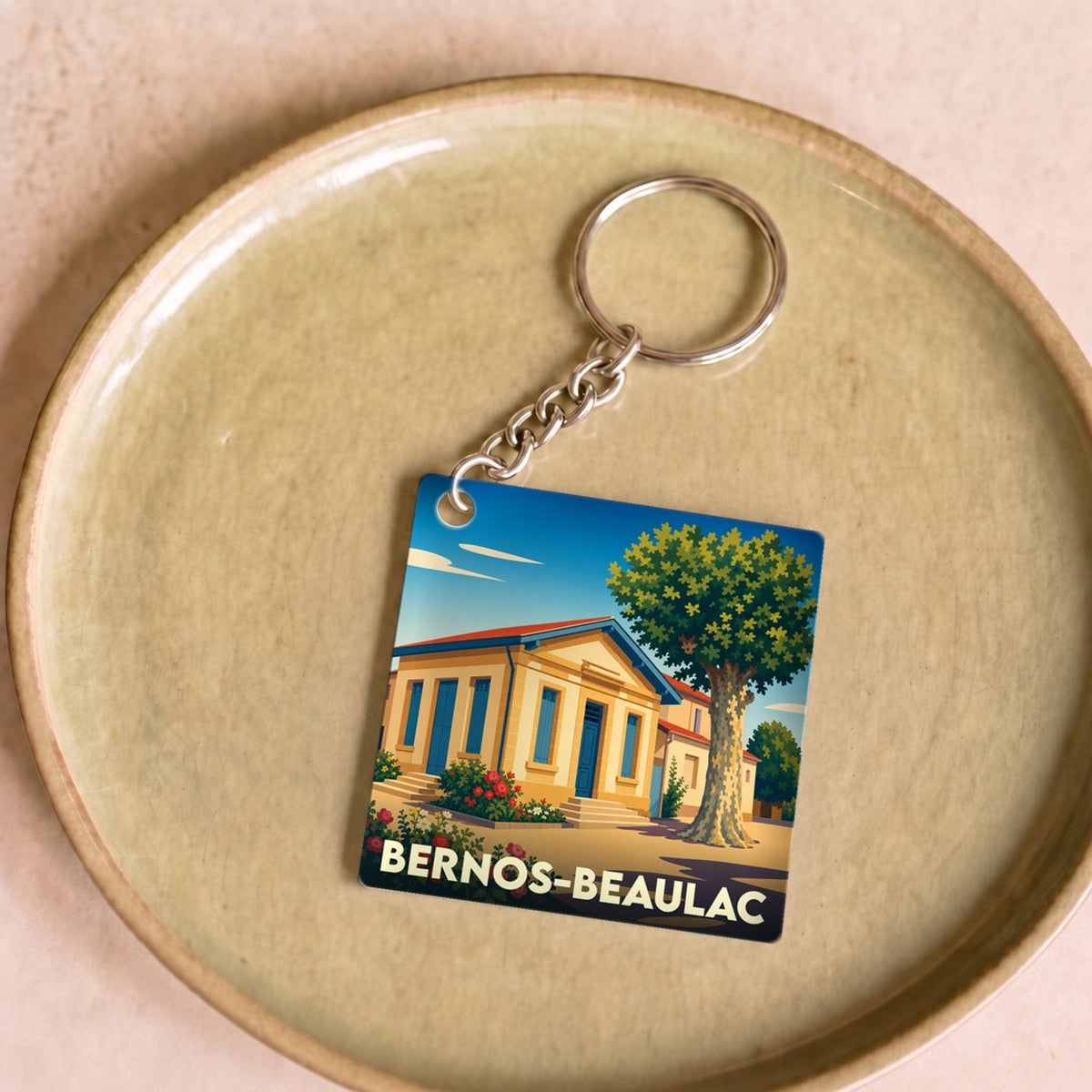 Porte-clés souvenir de la ville de Bernos-Beaulac avec une illustration stylisée.