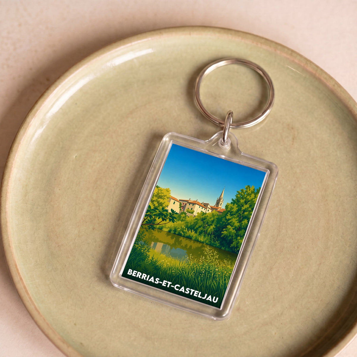 Porte-clés souvenir de la ville de Berrias-et-Casteljau avec une illustration stylisée du paysage local.