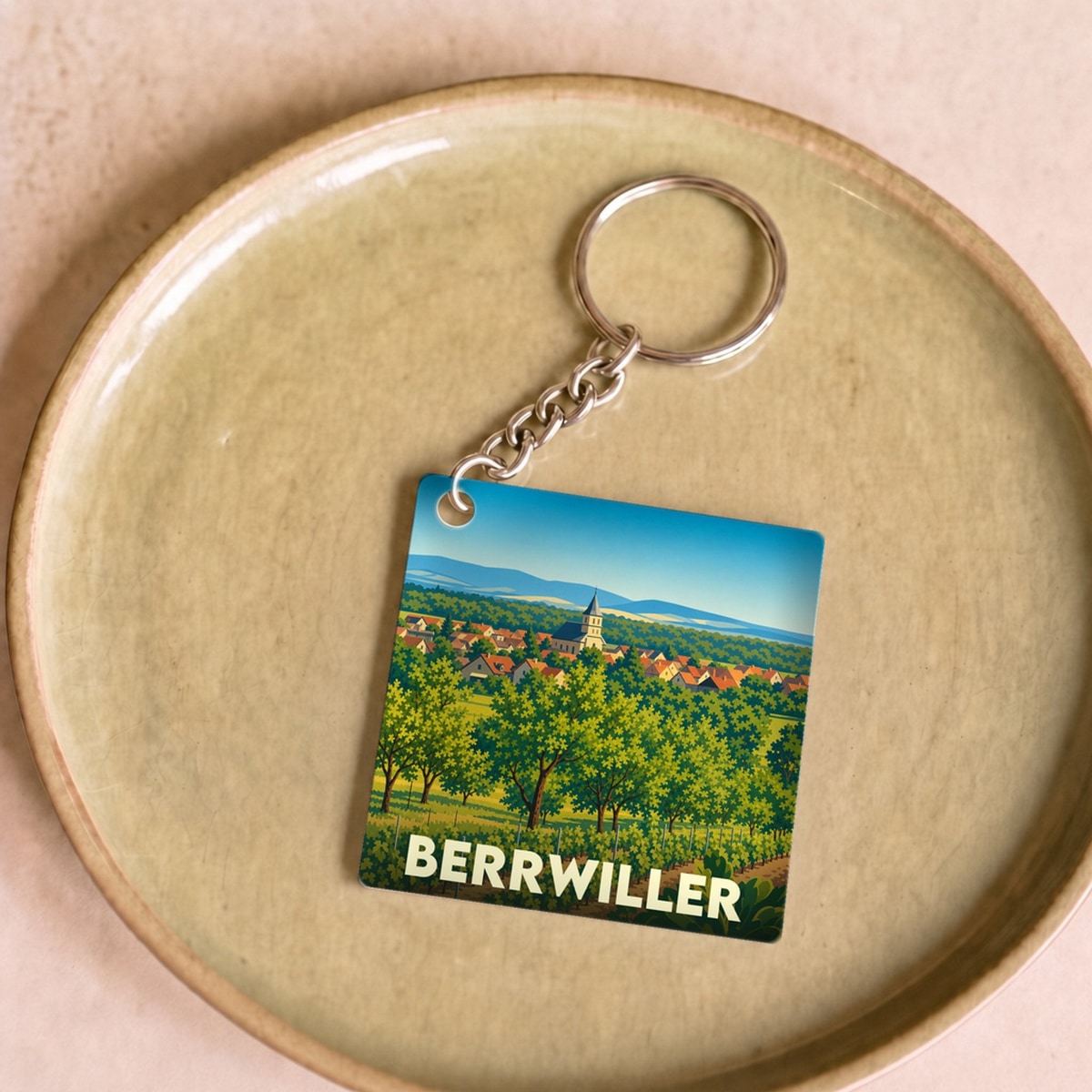 Porte-clés souvenir de la ville de Berrwiller avec une illustration stylisée de son paysage de vignobles.