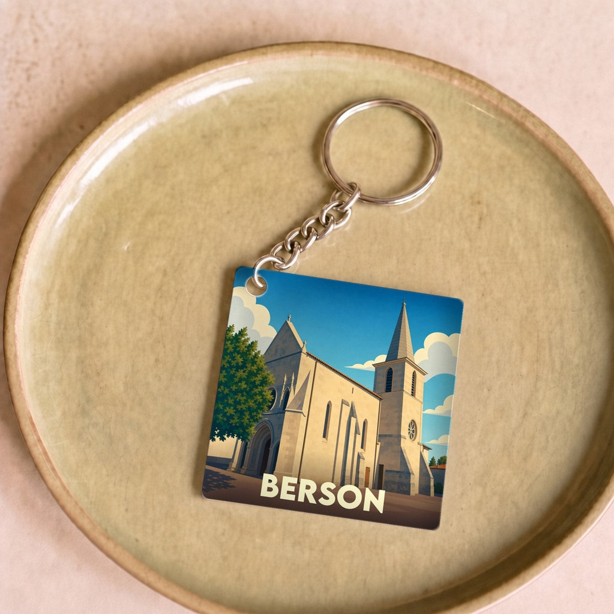 Porte-clés souvenir de la ville de Berson avec une illustration stylisée de son église.