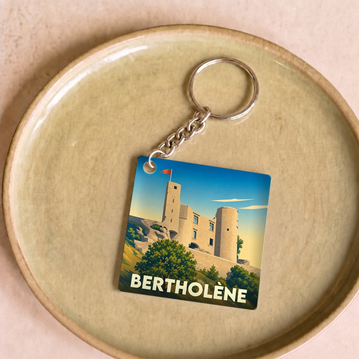 Porte-clés souvenir de la ville de Bertholène avec une illustration stylisée de son château.