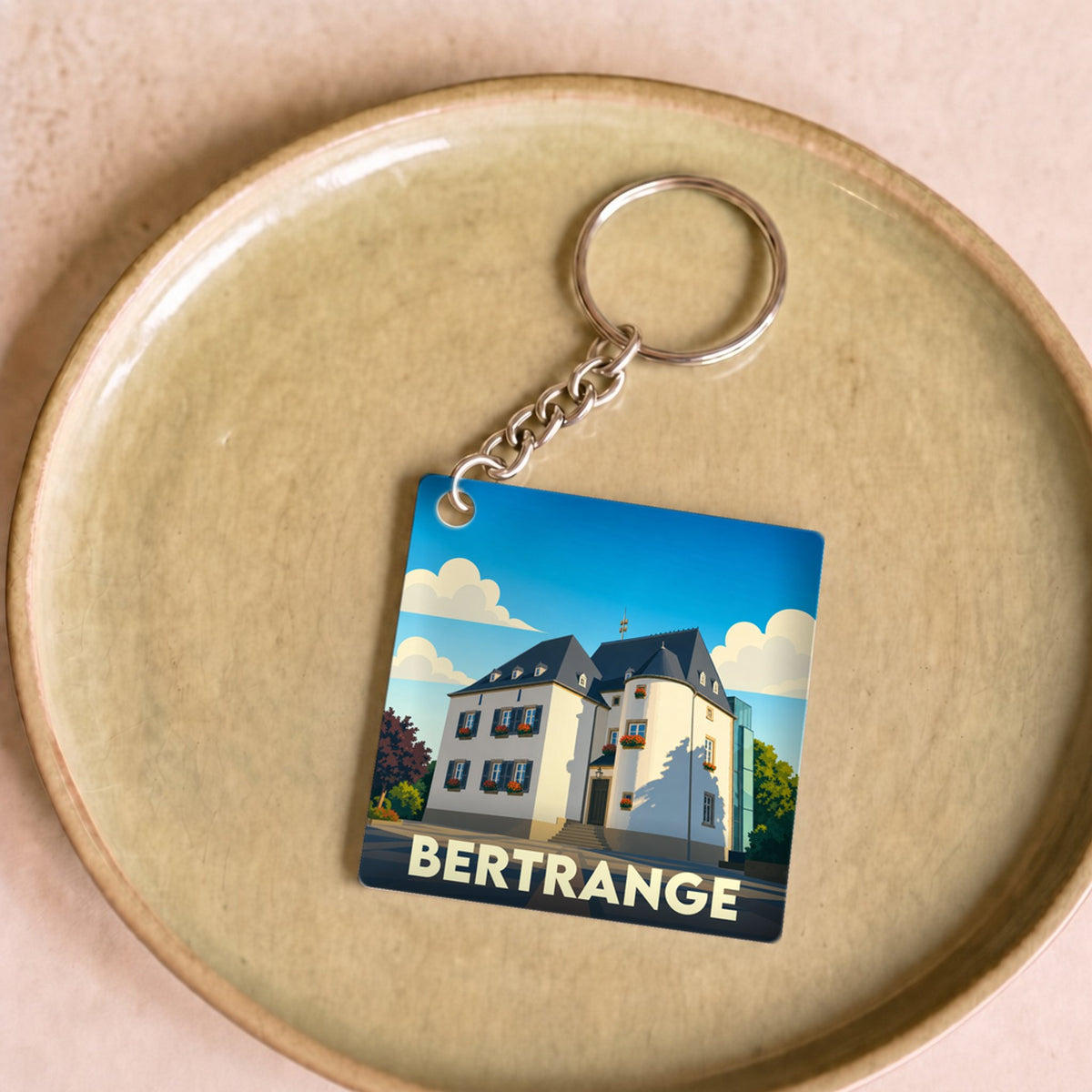 Porte-clés souvenir de la ville de Bertrange avec une illustration stylisée de sa mairie.