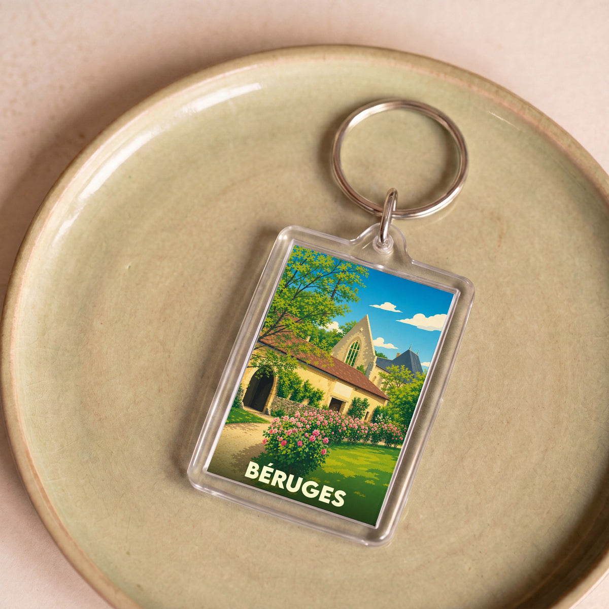 Porte-clés souvenir de la ville de Béruges avec une illustration stylisée.