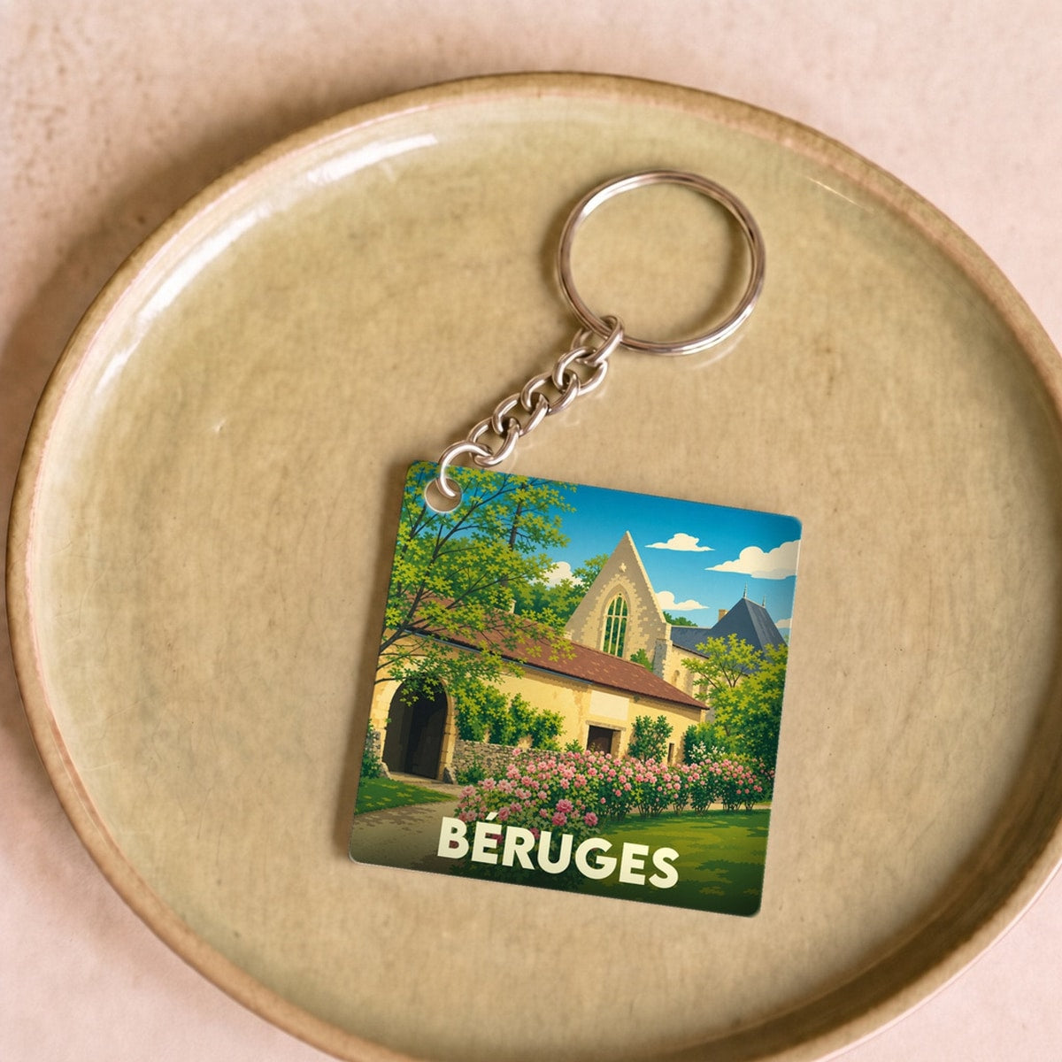 Porte-clés souvenir de la ville de Béruges avec une illustration stylisée.