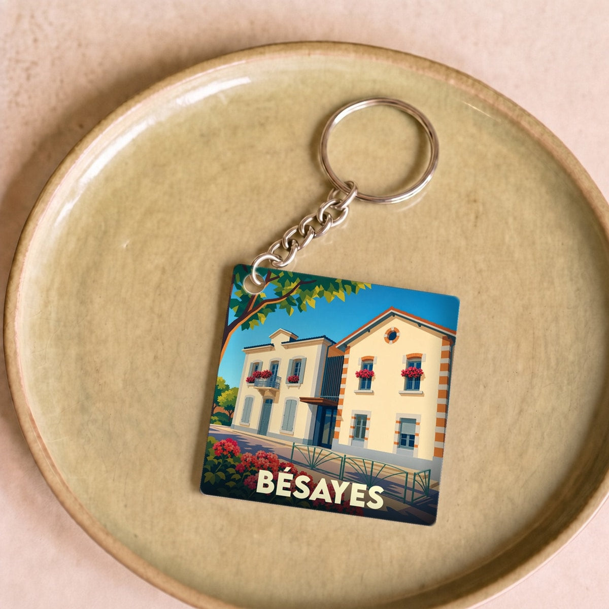 Porte-clés souvenir de la ville de Bésayes avec une illustration stylisée.
