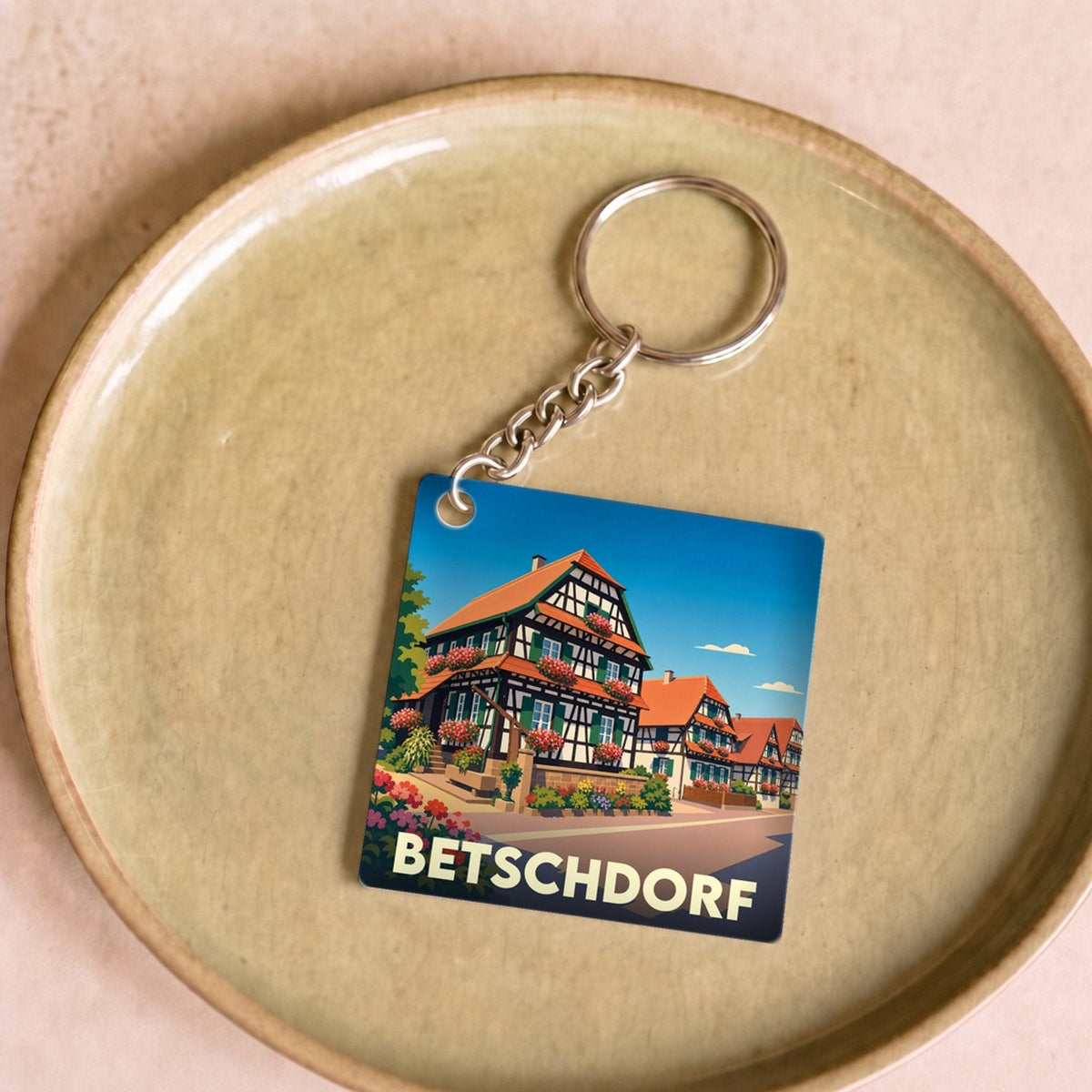 Porte-clés souvenir de la ville de Betschdorf avec une illustration stylisée de maisons à colombages.