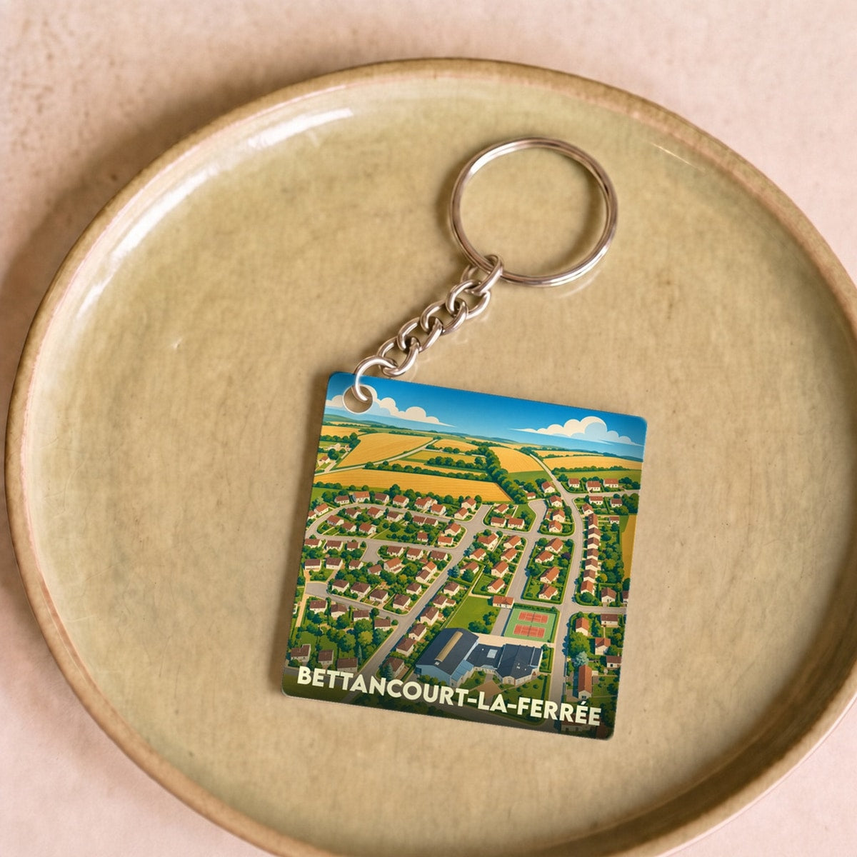 Porte-clés souvenir de la ville de Bettancourt-la-Ferrée avec une illustration stylisée vue du ciel.