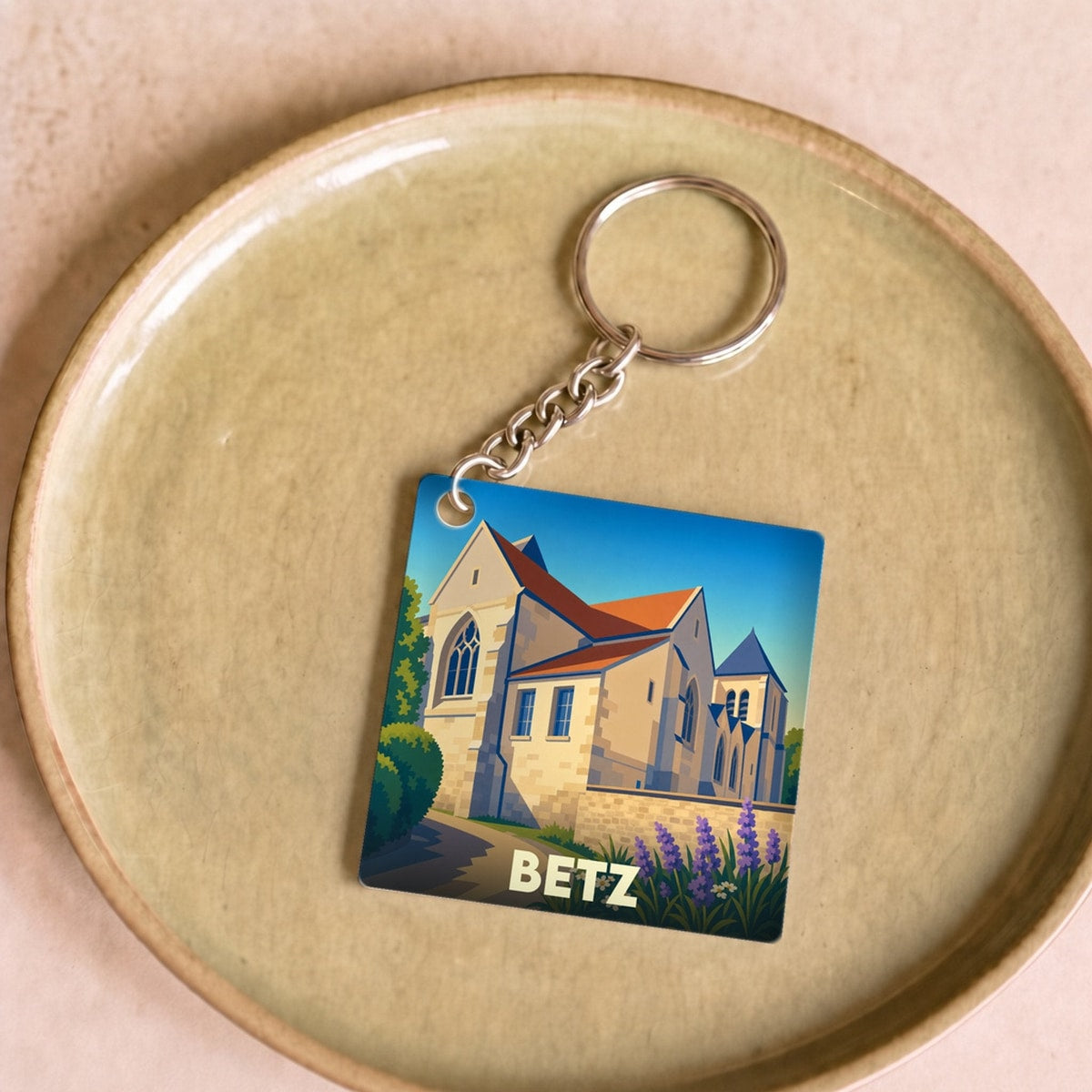 Porte-clés souvenir de la ville de Betz avec une illustration stylisée de son église.
