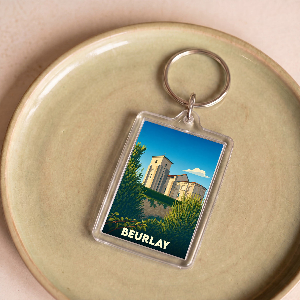 Porte-clés souvenir de la ville de Beurlay avec une illustration stylisée de son église.