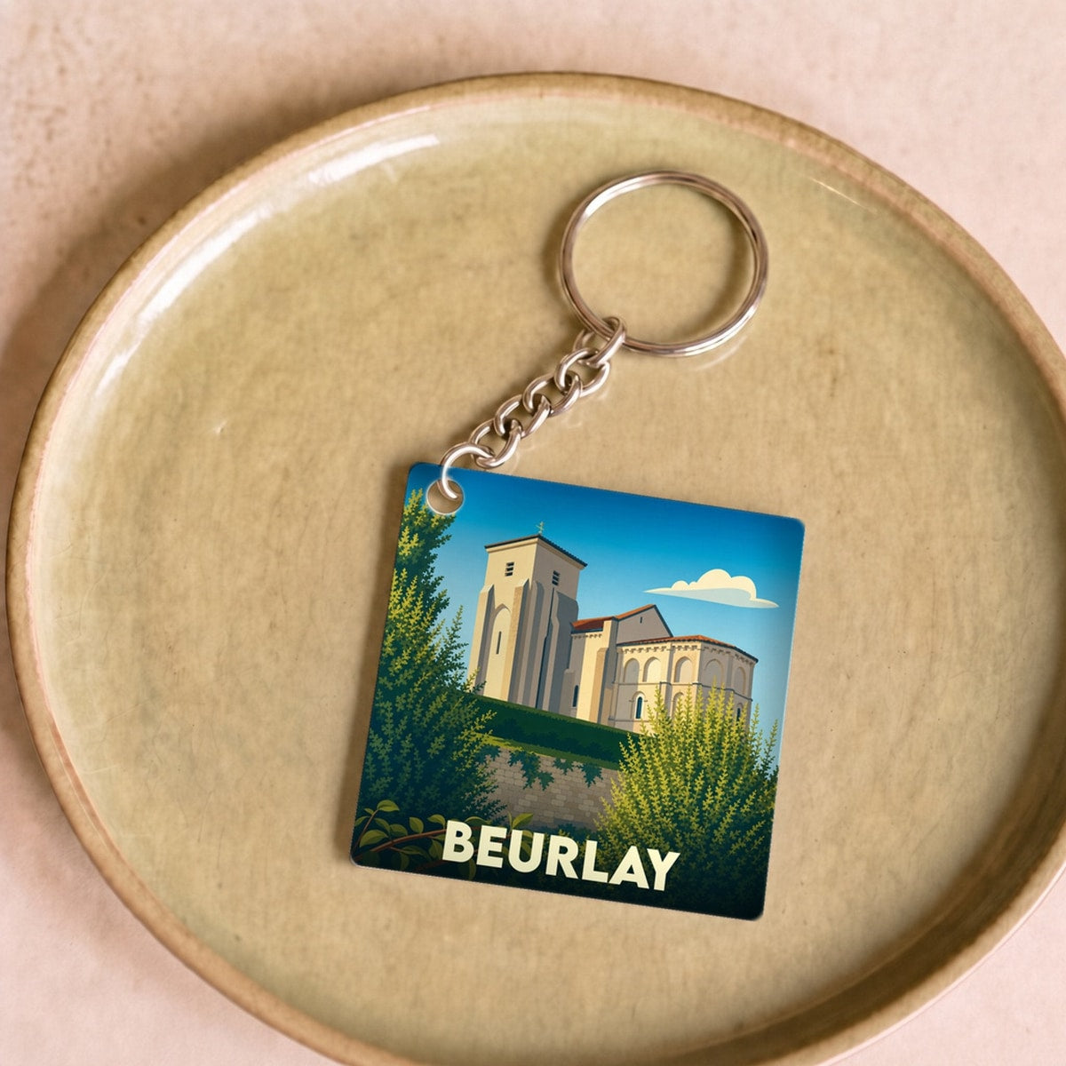 Porte-clés souvenir de la ville de Beurlay avec une illustration stylisée de son église.
