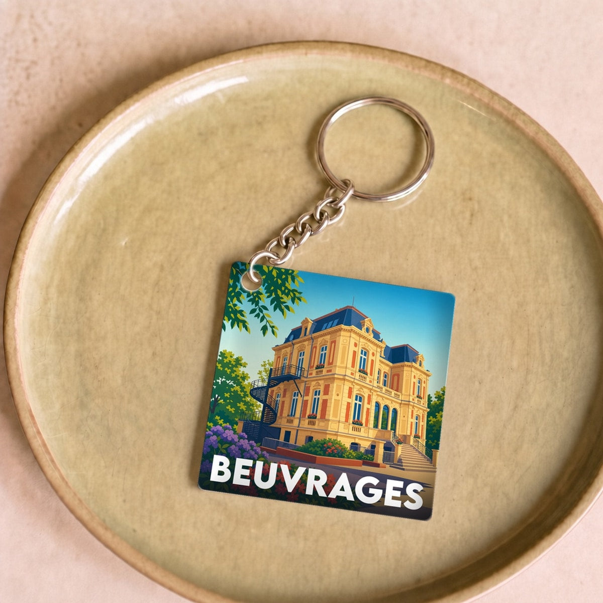 Porte-clés souvenir de la ville de Beuvrages avec une illustration stylisée d'un bâtiment historique.